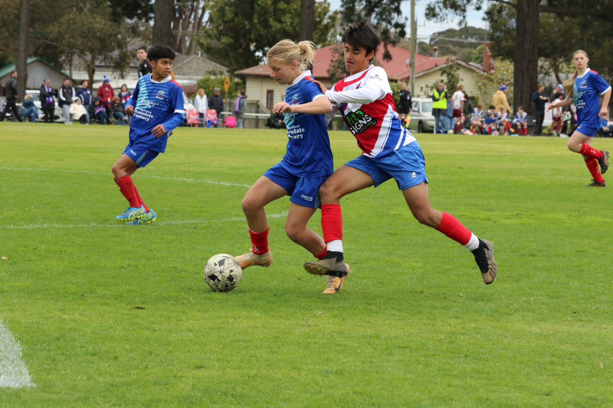 Hannah Titmarsh controlling the ball supported by Zach Coldora and Isabella Gajewski.